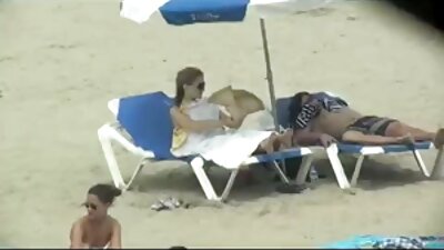 Prsata žena nudistkinja pozira na plaži i seksualne slike